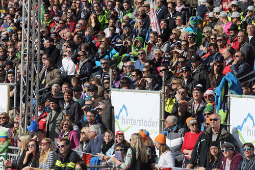 Zuschauerinnen und Zuschauer auf einer Tribüne bei einem Skirennen in Hinterstoder
