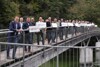 Landesrat Stefan Kaineder mit Gemeindevertreterinnen und -vertretern auf einer Brücke