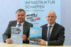 Infrastruktur-Landesrat Mag. Günther Steinkellner und Vizebürgermeister Dipl.-Ing. Markus Hein sitzen an einem Tisch dahinter ein Roll-Up  Infrastruktur schaffen  Zukunftsressort - mobil ans Ziel