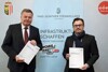 Landesrat Günther Steinkellner und Abteilungsleiter Stefan Dobler präsentieren das Baustellenprogramm 2022 vor der Pressewand mit der Aufschrift Infrastruktur schaffen