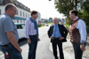 Markus Furtner, Bauamtsleiter, Bgm. Ing. Franz Angerer, LR Ing. Wolfgang Klinger und Stefan Schneebauer vor einer befahrenen Straße, im Hintergrund Häuser und Gewerbebetriebe