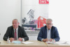 Landtagspräsident Wolfgang Stanek und IWS-Präsident Gottfried Kneifel an einem Tisch, im Hintergrund Plakat der Initiative Wirtschaftsstandort OÖ