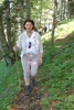 Agrar-Landesrätin Michaela Langer-Weninger geht mit einem Stock in der Hand auf einem Waldweg bergauf.