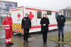 Peter Haslinger in Rot-Kreuz-Uniform, Dr. Walter Aichinger, LH-Stellvertreterin Mag.a Christine Haberlander und Thomas Märzinger, alle mit FFP2-Maske, vor einem Rot-Kreuz-Container