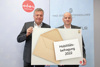 Landesrat Mag. Günther Steinkellner und Ing. Berthold Pfeiffer halten das Logo zur Mobilitätsbefragung 2022