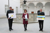 DI Martin Raxendorfer (Ablaufplan Agrarpreis 2022), LRin  Michaela Langer-Weninger (Pokal - Oö. Wappen und Landschaftsbild auf durchsichtigem Hartplastik) und  AL Mag. Hubert Huber (Werbeplakat des Agrarpreises 2022) stehen im Arkadenhof des Landes vor dem Brunnen und halten jeweils eine Plakat  bzw. Pokal in der Hand. 