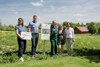 Gerlinde Larndorfer (Bodenbündnis), Landesrat Stefan Kaineder, Erich Bangerl (Geschäftsführer Blumensaat Bangerl), Margit Rinner (Blumensaat Bangerl) und Agnes Reiter (Bürgermeisterin Raab) stehen nebeneinander in einer Wiese, Kaineder und Bangerl stützen sich auf einem Saatgut-Vermehrungs-Schild ab, Larndorfer hält eine Tafel mit der Aufschrift „Hier wächst eine Bienenweide!“