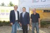 Bürgermeister Dieter Lang, Landeshauptmann-Stellvertreter Dr. Manfred Haimbuchner und Vizebürgermeister Fanz Geßwagner stehen nebeneinander vor einem Bauplakat mit Illustration des Projekts    