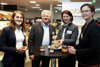 Stefanie Payrleitner, Karl Grabmayr, Landesrätin Michaela Langer-Weninger und Elisabeth Lanzer stehen nebeneinander in einem Lebensmittel-Verkaufsladen um einem Stehtisch, auf dem sich Gebäck und Honiggläser befinden.