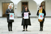 Birgit Mayr-Mauhart, Landesrätin Birgit Gerstorfer und Theresia Schlöglmann stehen nebeneinander im Hof des Ursulinenhof-Gebäudes, alle halten jeweils ein Poster zur Kampagne in Händen