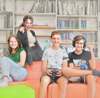 Vier Jugendliche sitzen auf einer Couch und spielen ein Computerspiel, im Hintergrund Bücherregal
