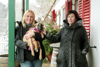 Johanna Stadler und Landesrätin Birgit Gerstorfer stehen nebeneinander unter dem Vordach eines Hauses, im Hintergrund ein Weihnachtsbaum, Johanna Stadler hält einen Hundewelpen in den Armen, der von Landesrätin Gerstorfer gestreichelt wird