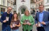 Mag. Norbert Rainer, Mag.a Magdalena Glasner, Silvia Huber und Landesrat Stefan Kaineder stehen nebeneinander auf einer Innenstadt-Straße in Wels, alle halten Broschüren in Händen, im Hintergrund der Welser Stadtturm