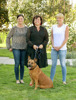 Bettina Hubner, Landesrätin Birgit Gerstorfer und Marlies Zachbauer stehen nebeneinander auf einem Rasen, Birgit Gerstorfer hält einen vor ihr sitzenden Hund an der Leine