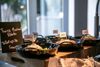 Ein Tisch des Courtyard by Marriott mit gekochten/gebratenen Lebensmitteln in Pfannen und Genussland-Schildchen.