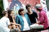 Landesrätin Birgit Gerstorfer im Gespräch mit vier Jugendlichen, im Hintergrund eine Mauer mit Graffitimalerei
