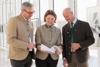 Franz Waldenberger, Landesrätin Michaela Langer-Weninger und Herbert Sieghartsleitner stehen nebeneinander im Gangbereich des OÖ. Presseclubs und blicken in einen Begutachtungsentwurf 