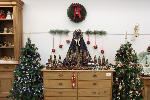 Regal und Kommode mit weihnachtlicher Dekoration, zwei geschmückte Christbäume