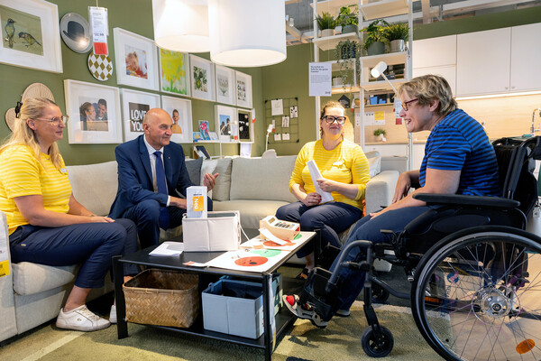 Sozial-Landesrat Christian Dörfel, Annecatrien Niemeijer-Berenst, Market Managerin von IKEA Linz-Haid, und Marlene Foller, People & Culture Managerin von IKEA Linz-Haid, im Gespräch mit einer Rollstuhl fahrenden Mitarbeiterin von IKEA.