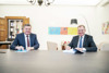 Landesrat Mag. Günther Steinkellner und LH Mag. Thomas Stelzer zusammen an einem Tisch in einem Büro, LH Stelzer unterschreibt ein Schriftstück.