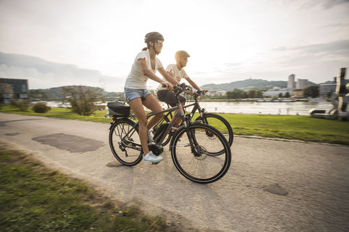 E-Biker radeln im Donaupark in Linz