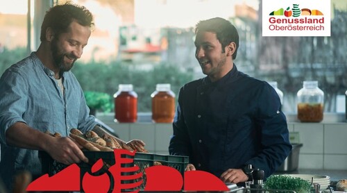 Zwei Personen in einer Küche, Korb mit Gebäck, im Hintergrund Vorratsgläser