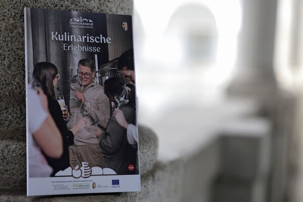 Erlebnis-Guide steht an einer Mauer angelehnt.