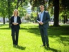 Ministerin Leonore Gewessler und Landesrat Stefan Kaineder stehen nebeneinander auf einer Wiese in einem Park