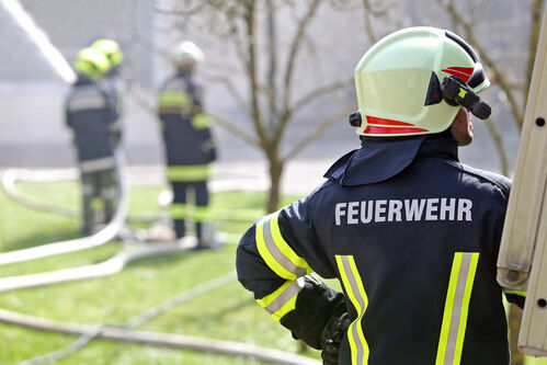 Feuerwehrleute im Einsatz, Wasserschlauch