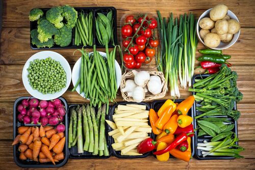Verschiedene Gemüsesorten appetitlich angerichtet liegen auf einem Holztisch