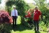 Landesrat Max Hiegelsberger und der Präsident des Landesobst- und Gartenbauverbands OÖ Roland Feichtinger in einem Garten, im Hintergrund Bogen mit Bepflanzung und blühende Sträucher