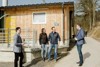 Sebastian Bohrn Mena, Anita und Herbert Holzinger mit Landesrat Stefan Kaineder vor einem Stallgebäude