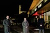 Landesrat Stefan Kaineder, Bürgermeisterin Nicole Eder und Astrophysiker Stefan Wallner vor einem Gebäude, im Hintergrund nächtlich beleuchtete Kirche und Straßenbeleuchtung