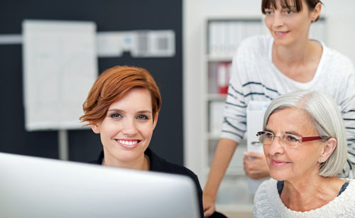 Drei Bürokolleginnen arbeiten gemeinsam erfolgreich an einem Projekt.