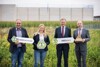 Johann Schwarzenhofer, Katrin Hohensinner, Landeshauptmann Mag. Thomas Stelzer und Landesrat Max Hiegelsberger stehen nebeneinander auf einer Blumenwiese und halten Schilder in Händen mit dem Symbol für eine Biene und der Beschriftung #BEEthechange, #BEEahero, im Hintergrund ein Betriebsgebäude