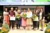 LR Michaela Langer-Weninger und Karl Ploberger stehen mit den Preisträgerinnen und Preisträger nach der Preisübergabe auf der Gartenland-geschmückten Bühne. Ein Teil der Personen hält einen Blumenstrauß bzw. eine A4-Scheckkarte in den Händen.