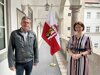 Leopold Gartner, Bürgermeister von Vorderweißenbach und Landesrätin Michaela Langer-Weninger stehen am Gang des Arkadenhofes im Linzer Landhaus nebeneinander; zwischen ihnen ist im Hintergrund eine Oberösterreich-Fahne zu sehen.  