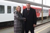 Dipl.-Ingin Eva Hackl und Landesrat Mag. Günther Steinkellner stehen nebeneinander auf einem Bahnsteig und reichen sich die Hand, im Hintergrund eine Zuggarnitur