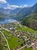 Hallstatt Bannwald: Ein Blick von oben auf Hallstatt mit seinem Bannwald und Bergen und dahinter ein See.