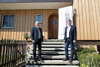 Landesrat Max Hiegelsberger und Josef Frauscher auf den Stufen eines Hauses in Holzbauweise