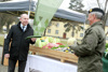 Landesrat Max Hiegelsberger mit Gurke und Brigadier Dieter Muhr mit Sellerieknolle vor einer großen Holzkiste mit Lebensmitteln: Äpfel, Kraut, Fleisch, Fische