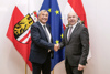 Mag. Rudolf Hoscher und Landtagspräsident Max Hiegelsberger stehen nebeneinander vor Oberösterreich-, EU- und Österreichfahnen und reichen sich die jeweils rechte Hand zum Handschlag 