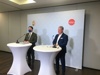 Landeshauptmann-Stv. Dr. Manfred Haimbuchner und Ing. Norbert Hartl, MSc MBA, stehen in einem Konferenzraum an zwei Stehtischen mit Mikrofonen