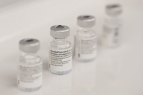 Vier kleine Glasbehälter, Aufschrift Pfizer-BioNTech COVID-19 Vaccine