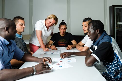 Migranten beim Unterricht mit einer Lehrerin