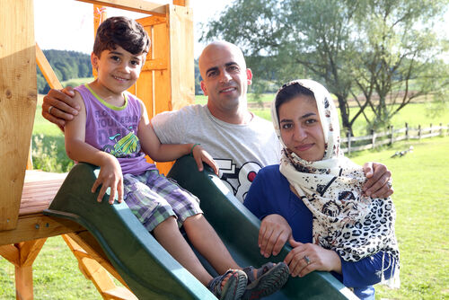 Flüchtlingsfamilie, ein Kind sitzt auf einer Rutsche.