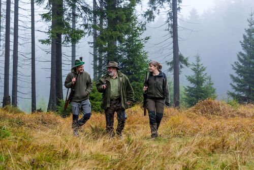 Drei Personen im Wald auf der Jagd