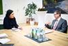 Tourismusministerin Elisabeth Köstinger und Wirtschafts- und Tourismus-Landesrat Markus Achleitner sitzen an einem großen Arbeitstisch beim Gespräch.
