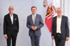 Axel Kühner, Landesrat Markus Achleitner und Manfred Hackl vor einer Oberösterreich-Fahne