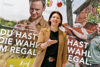Landesrätin Michaela Langer-Weninger steht vor Rollups mit Agrarmotiven und wirft einen Apfel in die Höhe